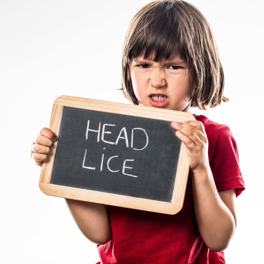 Child holding head lice sign