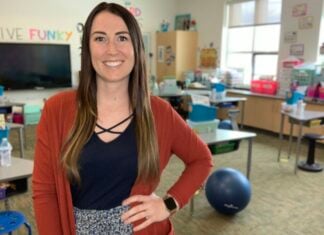 How Teachers Prepare Their Kids for School Casey Jeffers, a young woman smiles with her hand on her hip. She's in a classroom.