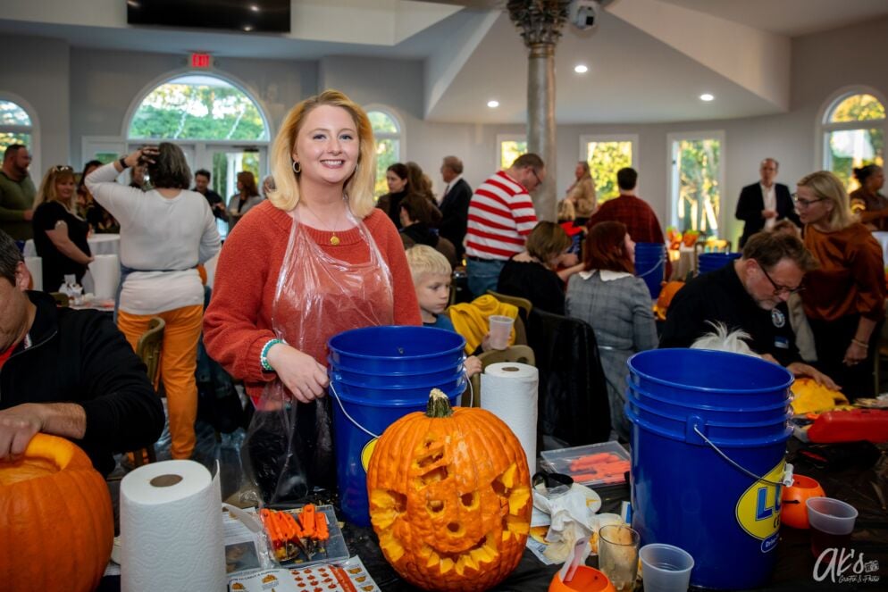 A woman carves a pumpkin at Pumpkins for a Purpose