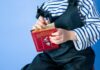 A child holding a copy of Alice in Wonderland