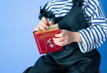A child holding a copy of Alice in Wonderland