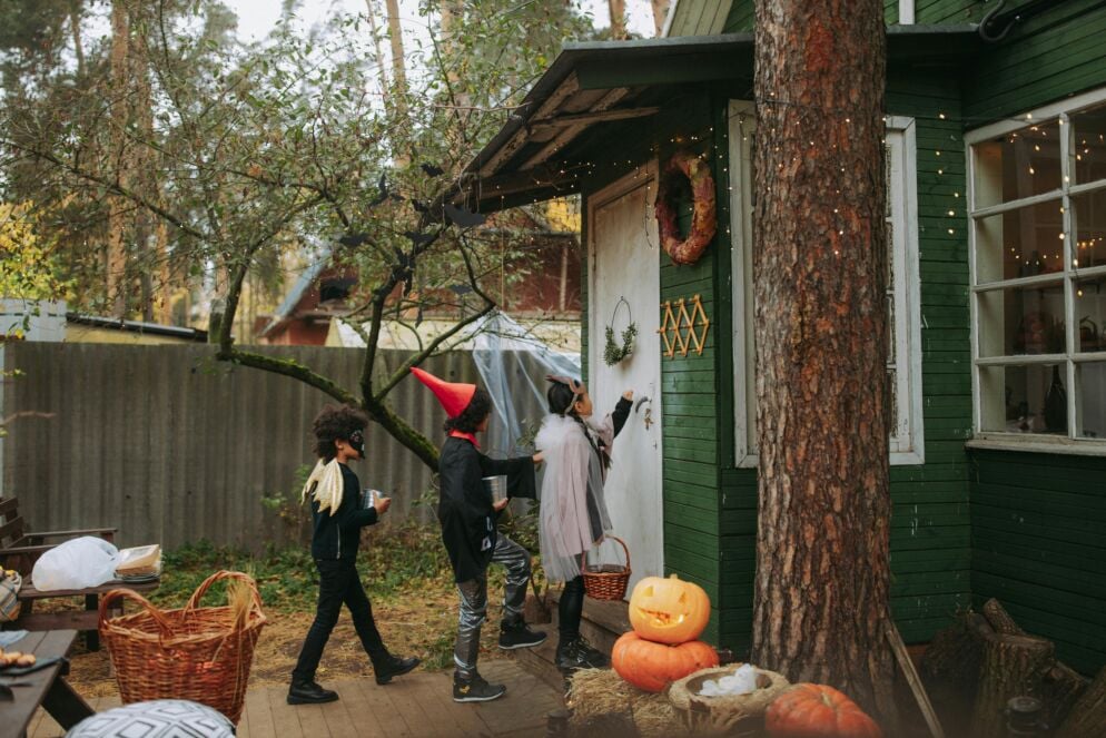 Three kids in Halloween costumes trick-or-treating