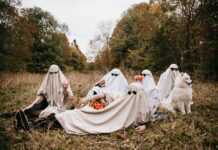 Halloween Fun in Frederick: Oct. 24-26 People dressed as ghosts pose on a field with a dog