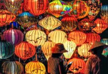 A woman standing in front of a display of lanterns at the Mid-Autumn Festival