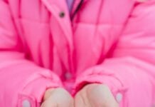 Child holding a heart made of snow