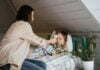 Parent wiping a sick child's forehead