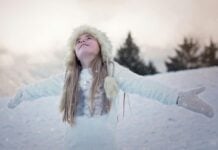 Girl standing with her arms outstretched in the snow