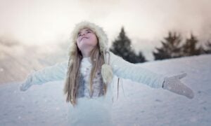 Girl standing with her arms outstretched in the snow