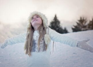 Girl standing with her arms outstretched in the snow