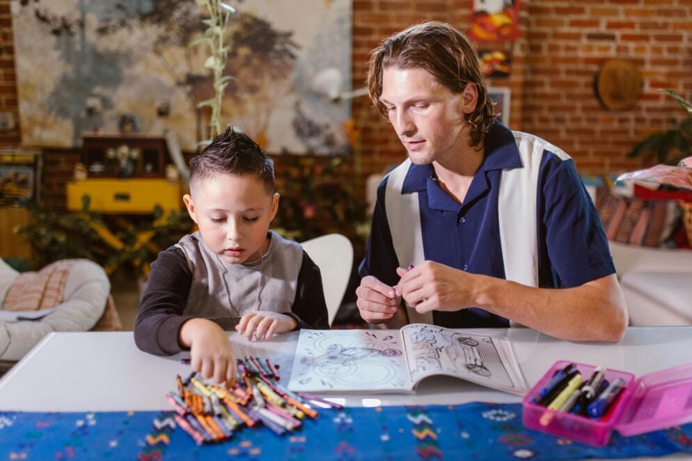 A child and a therapist looking at crayons and a coloring book