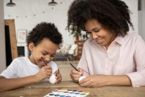 A mother and son painting eggs