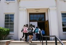 Children with backpacks enter a school