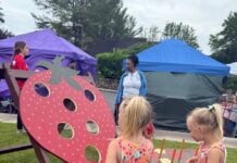 Two girls play a strawberry shaped beanbag toss at the strawberry festival