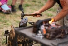 A blacksmith working with an anvil outside