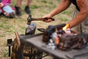 A blacksmith working with an anvil outside