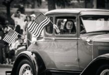 Fun in Frederick County This Independence Day Weekend: July 3-5 A girl holds an American flag out a car window at a Fourth of July parade