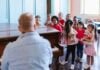 Man playing piano for a group of children